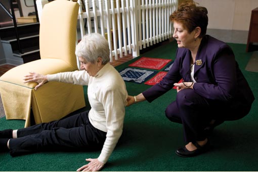 Elaine Cress assisting elderly woman with exercise